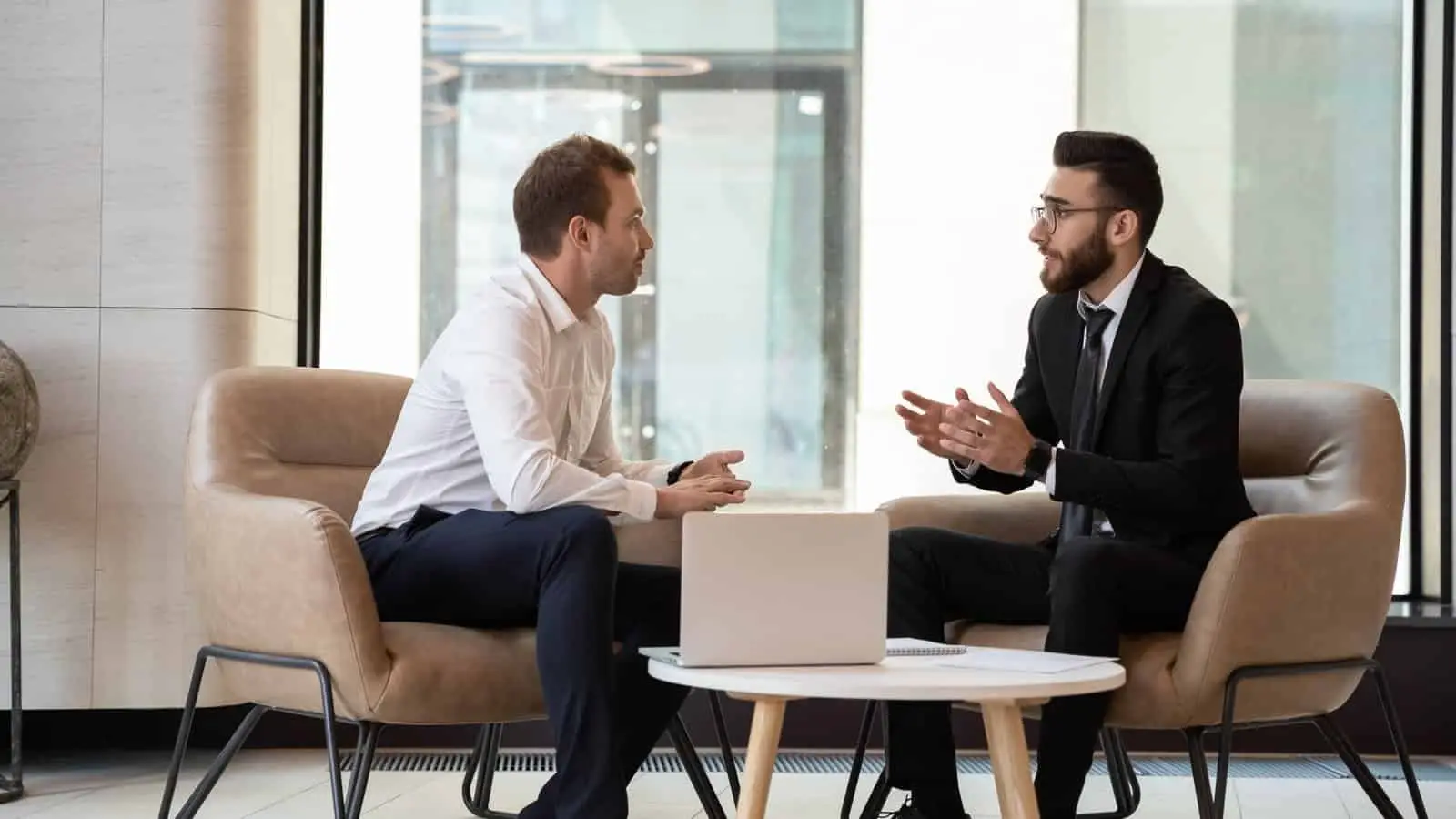 About Us Diverse group of businessmen discussing Managed Service Provider (MSP) strategies while seated in a modern office. Managed IT Services