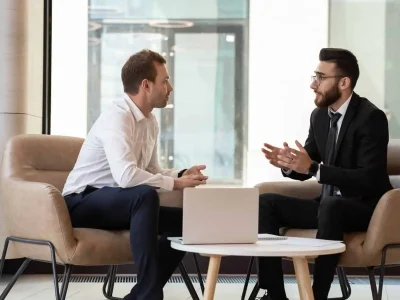 About Us Diverse group of businessmen discussing Managed Service Provider (MSP) strategies while seated in a modern office. Managed IT Services